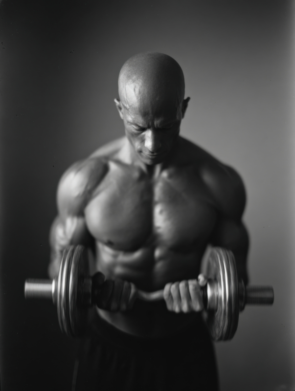 Muscular Man Lifting Dumbbells in Studio