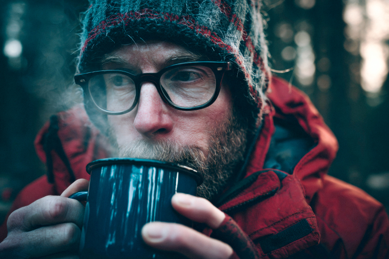 Man Enjoying Hot Drink in Winter Forest